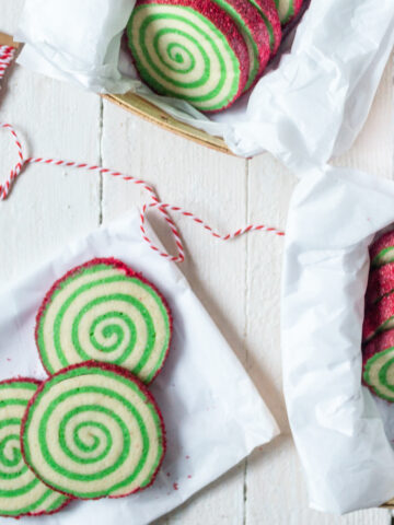 Green swirl Christmas pinwheel cookies with red sprinkle edges.