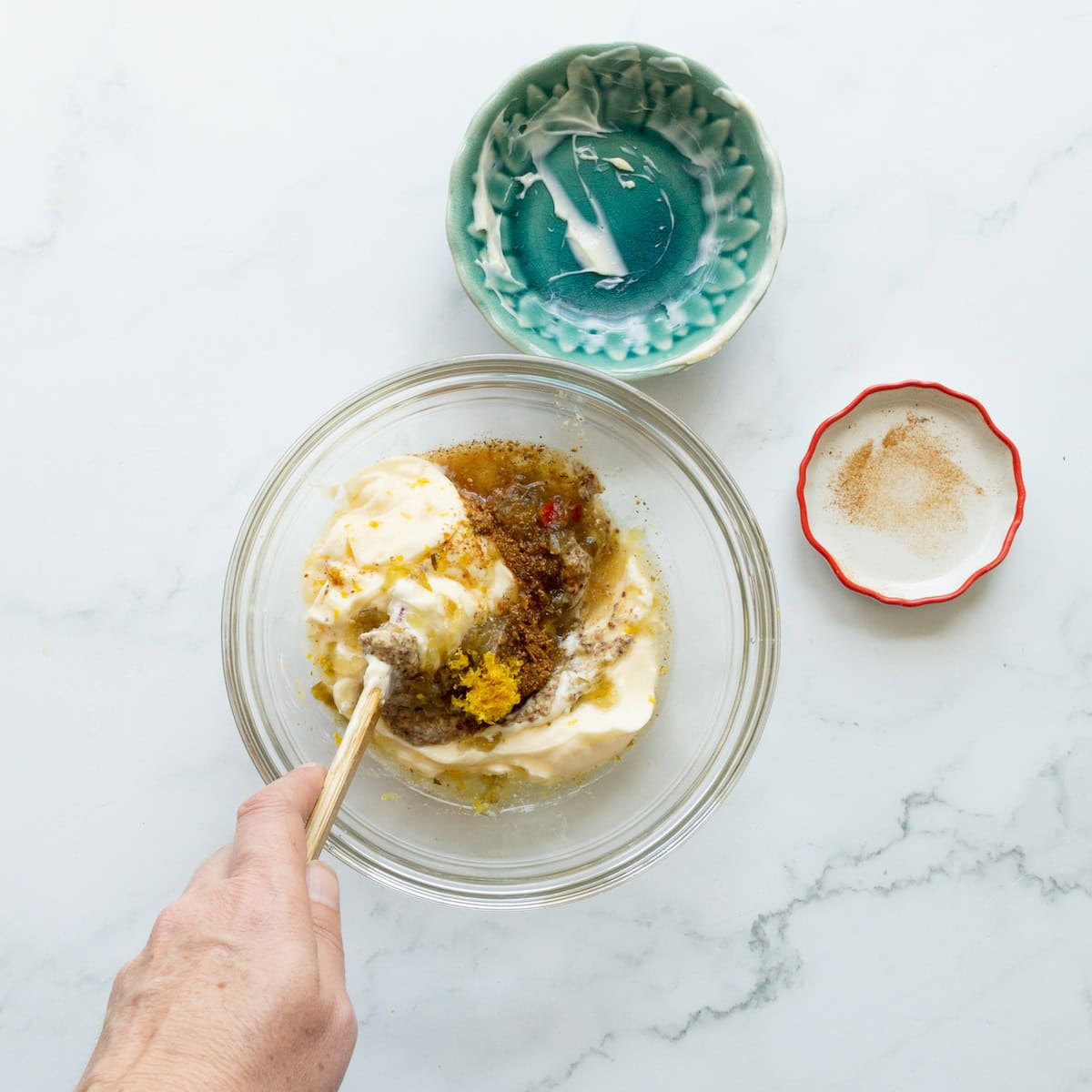 Stirring together the ingredients for Cajun tartar sauce in a glass bowl.