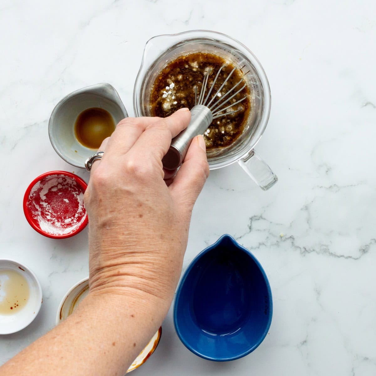 Whisking together the lo mein sauce in a liquid measuring cup.
