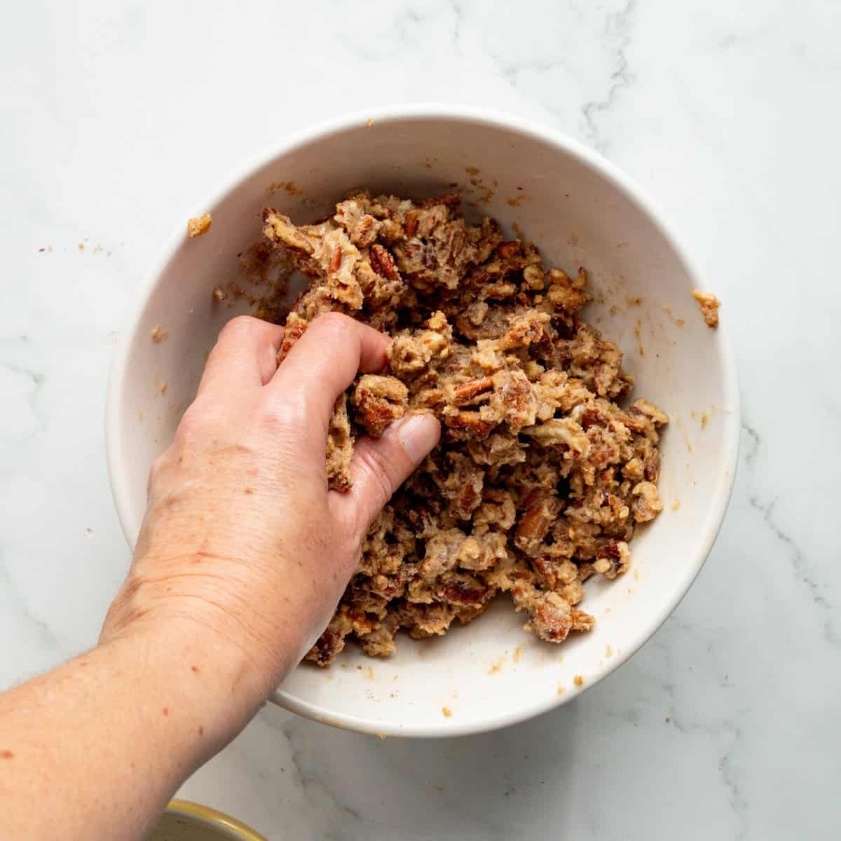 Mixing pecan streusel in a medium bowl.