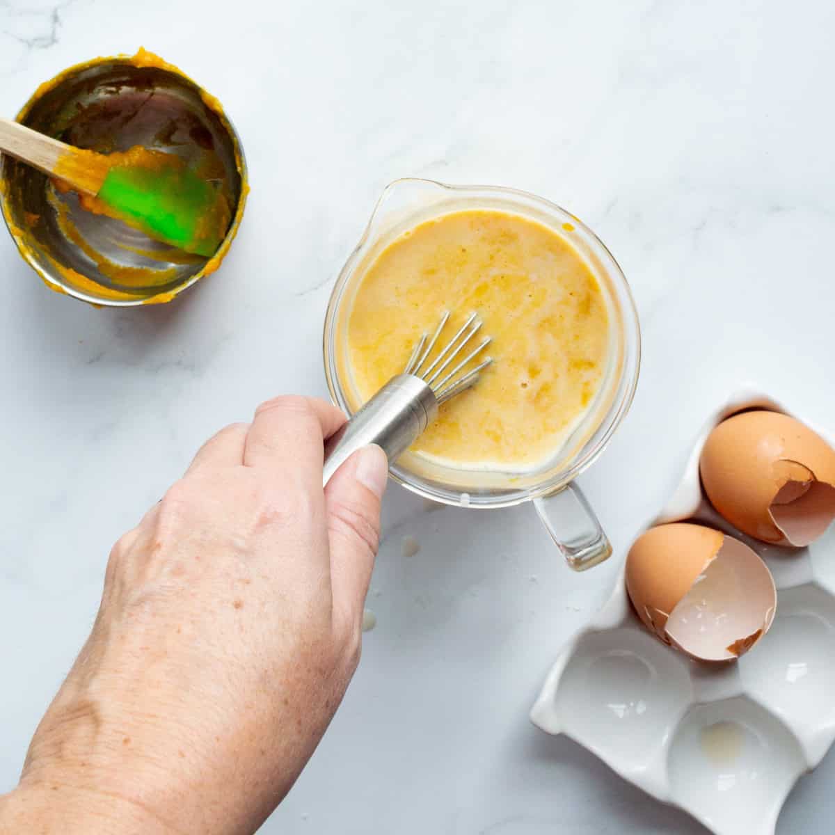 Whisking the wet ingredients for Trader Joe's pumpkin pancakes in a liquid measuring cup.