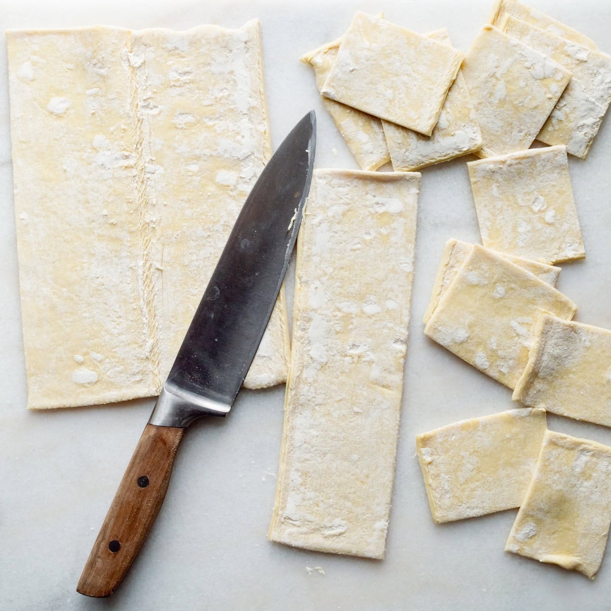 Cutting puff pastry into squares.