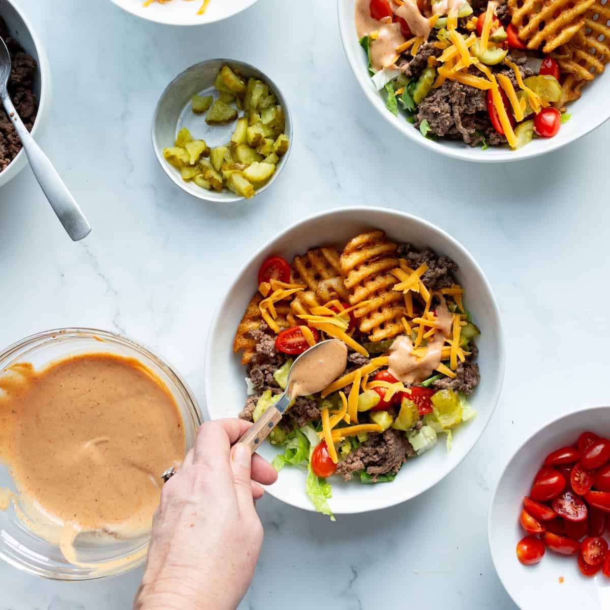 Spoon sauce over hamburger bowls.