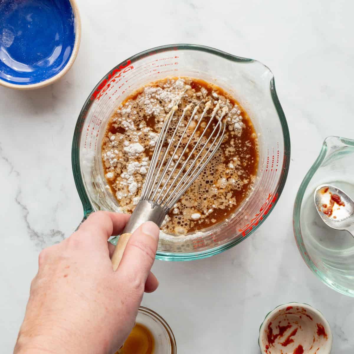 Whisking together the gravy ingredients for shepherd's pie in a glass measuring cup.