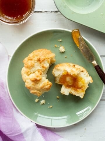 A 3-ingredient drop biscuit on a green plate with a spreader on the side.