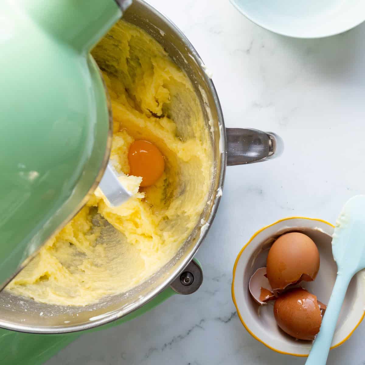 Adding eggs to the strawberry cake batter.