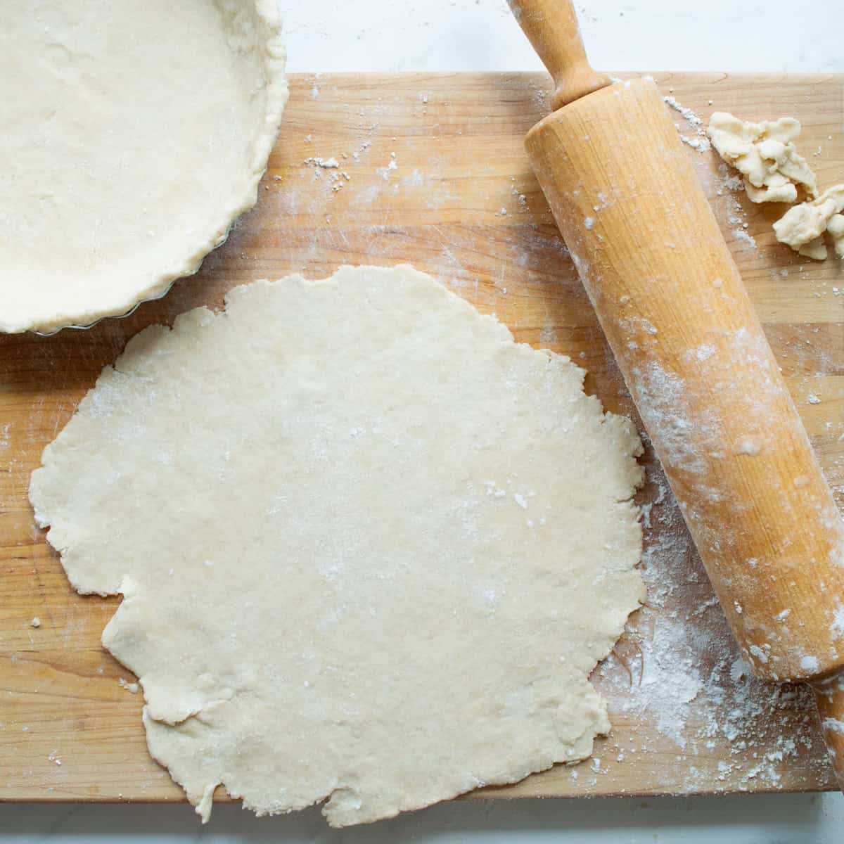 Rolling out pie dough on a floured surface.