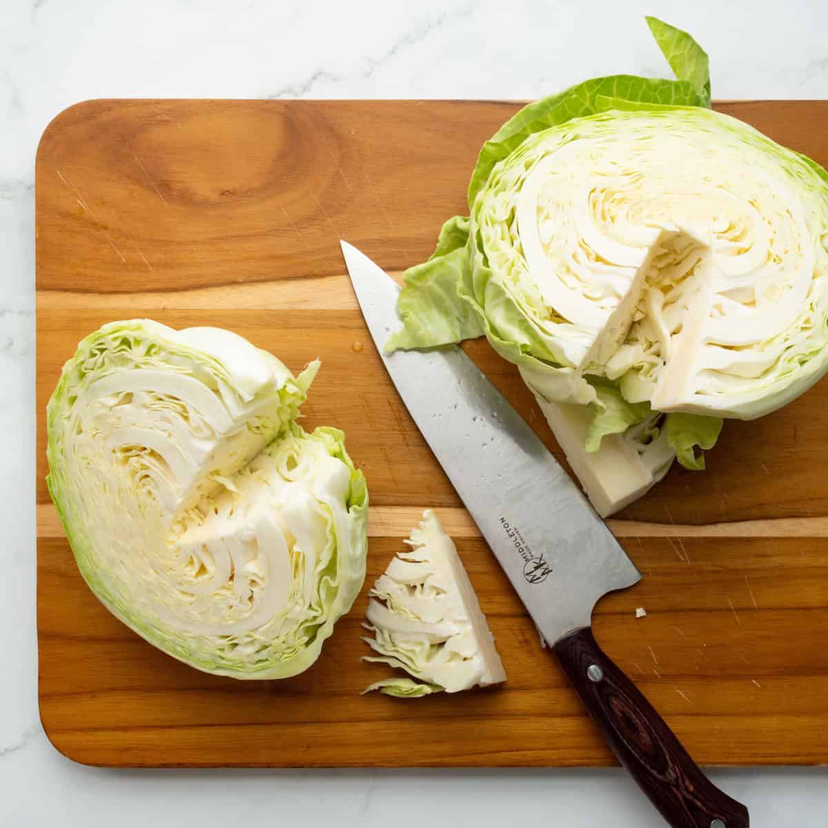 Cored cabbage on a cutting board.