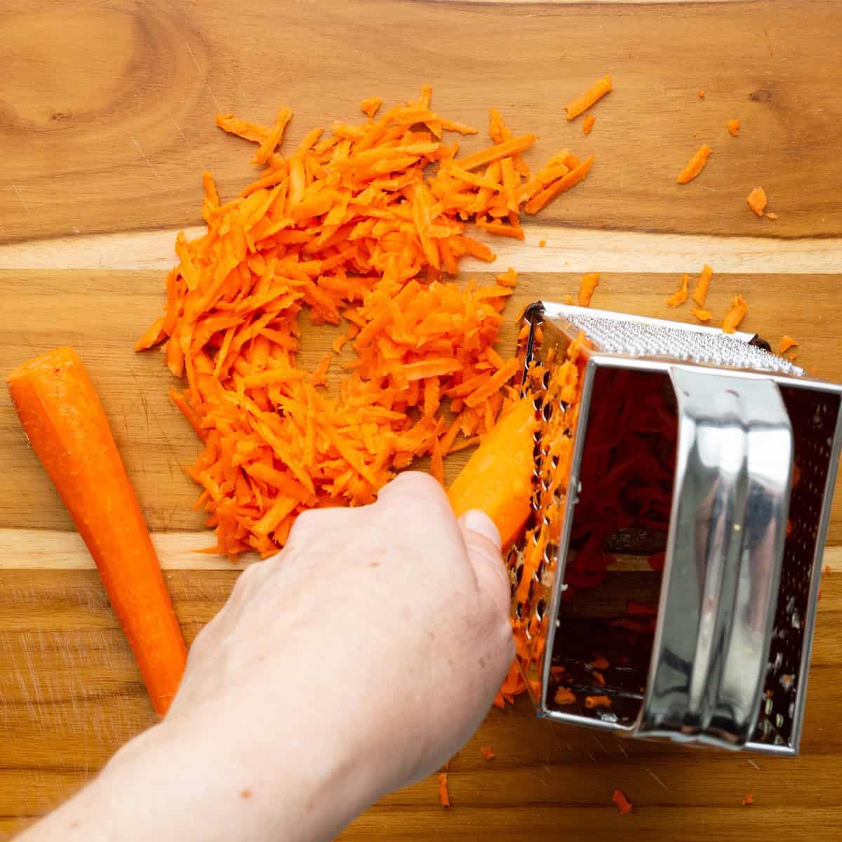 Grating carrots on a box grater.