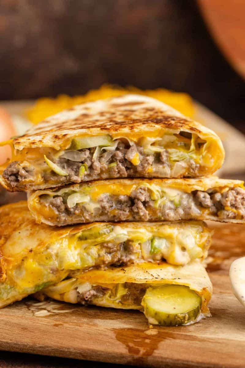 Big Mac quesadilla cut into wedges with ground beef, melted cheese, shredded lettuce, and pickle slices.