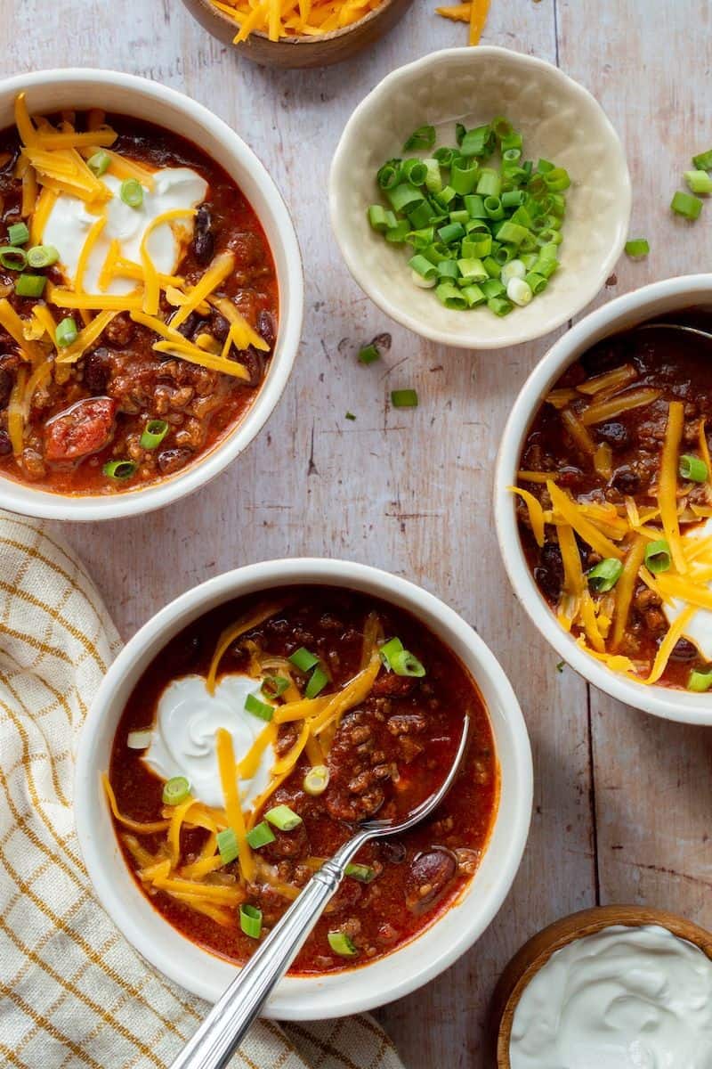 Beef chili topped with shredded cheese, sour cream, and sliced green onions.