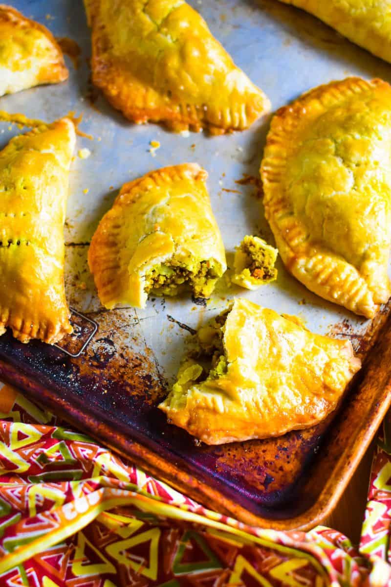 Nigerian meat pies with golden baked crusts and a savory meat filling, arranged on a baking sheet.