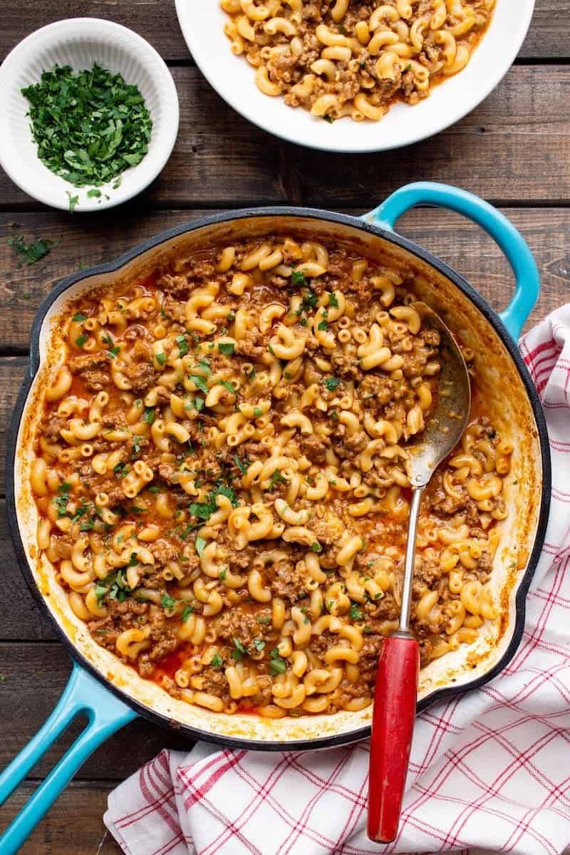 Homemade hamburger helper with ground beef and elbow macaroni in a creamy sauce, topped with chopped herbs.