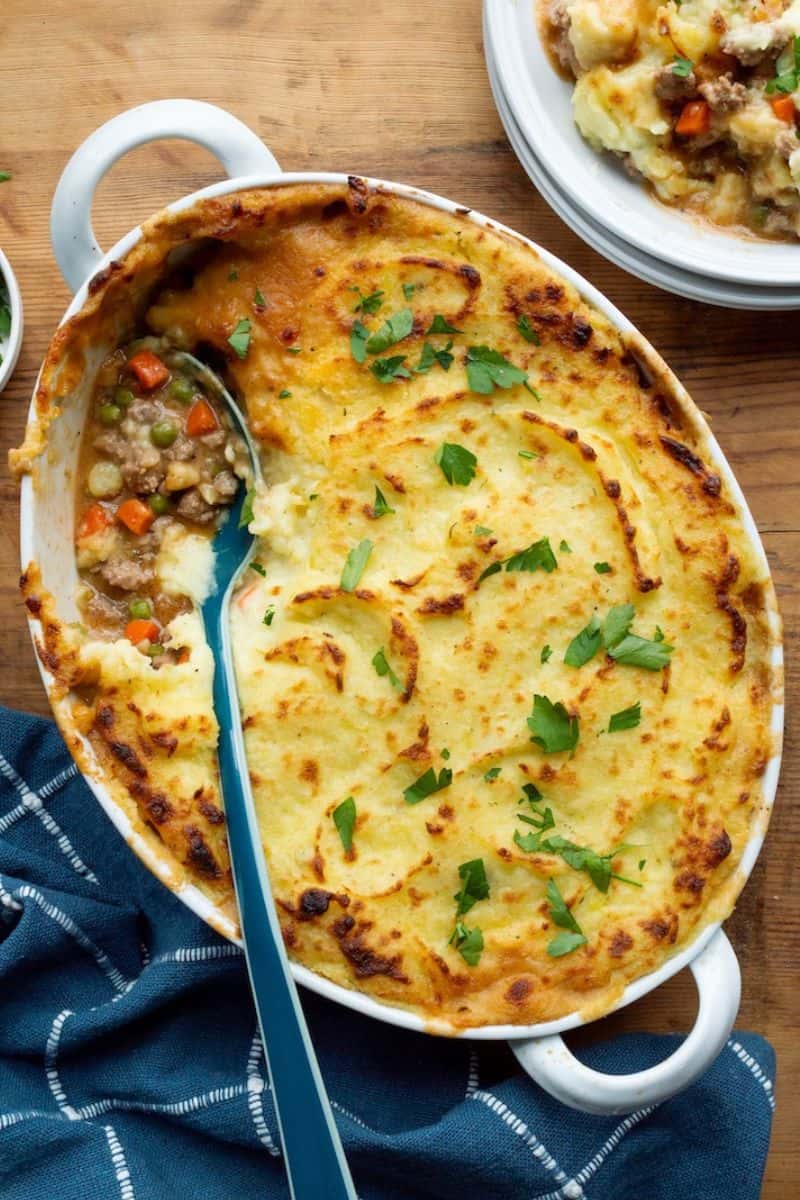 Turkey shepherd’s pie in a baking dish with a browned mashed potato topping and a visible scoop of filling.