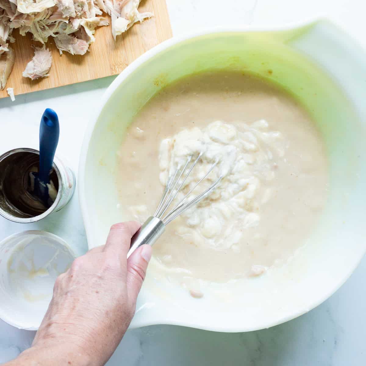 Whisking together the creamy filling for chicken poppyseed casserole.