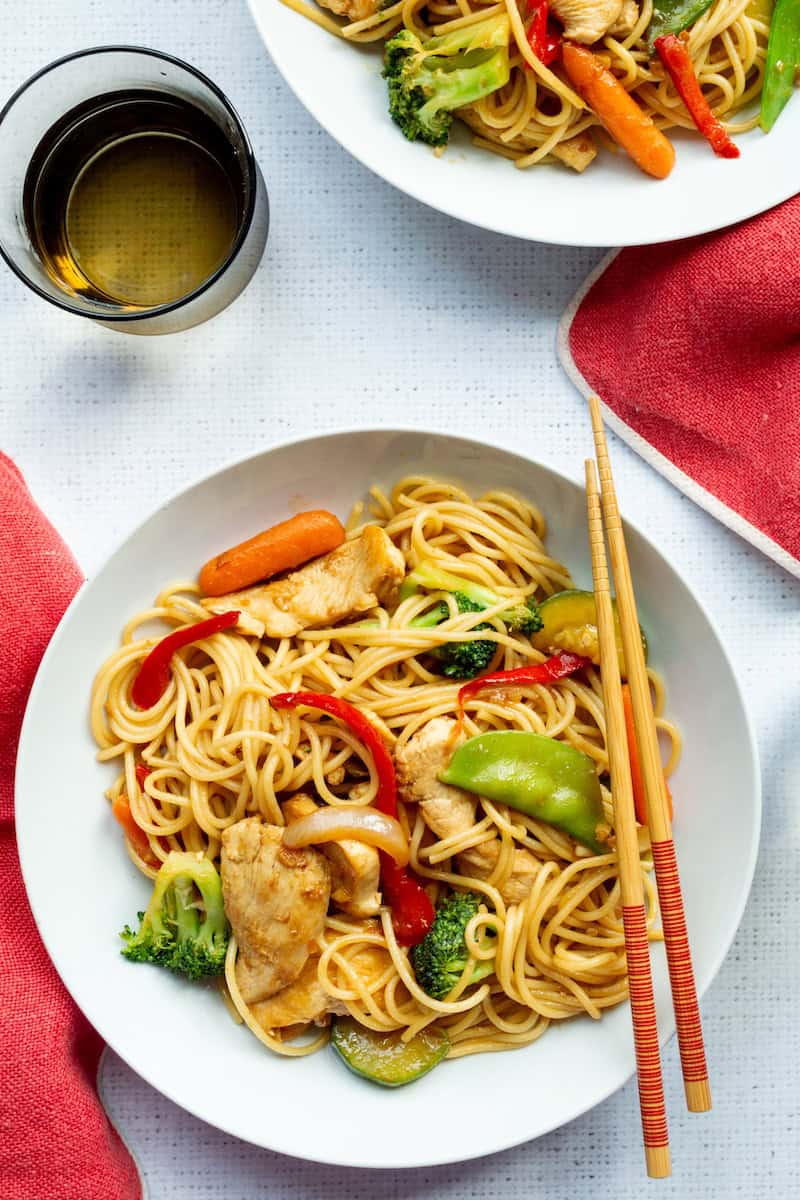 Copycat P.F. Chang's lo mein with chicken and vegetables tossed with broccoli, carrots, snap peas, and red bell peppers in a savory sauce.