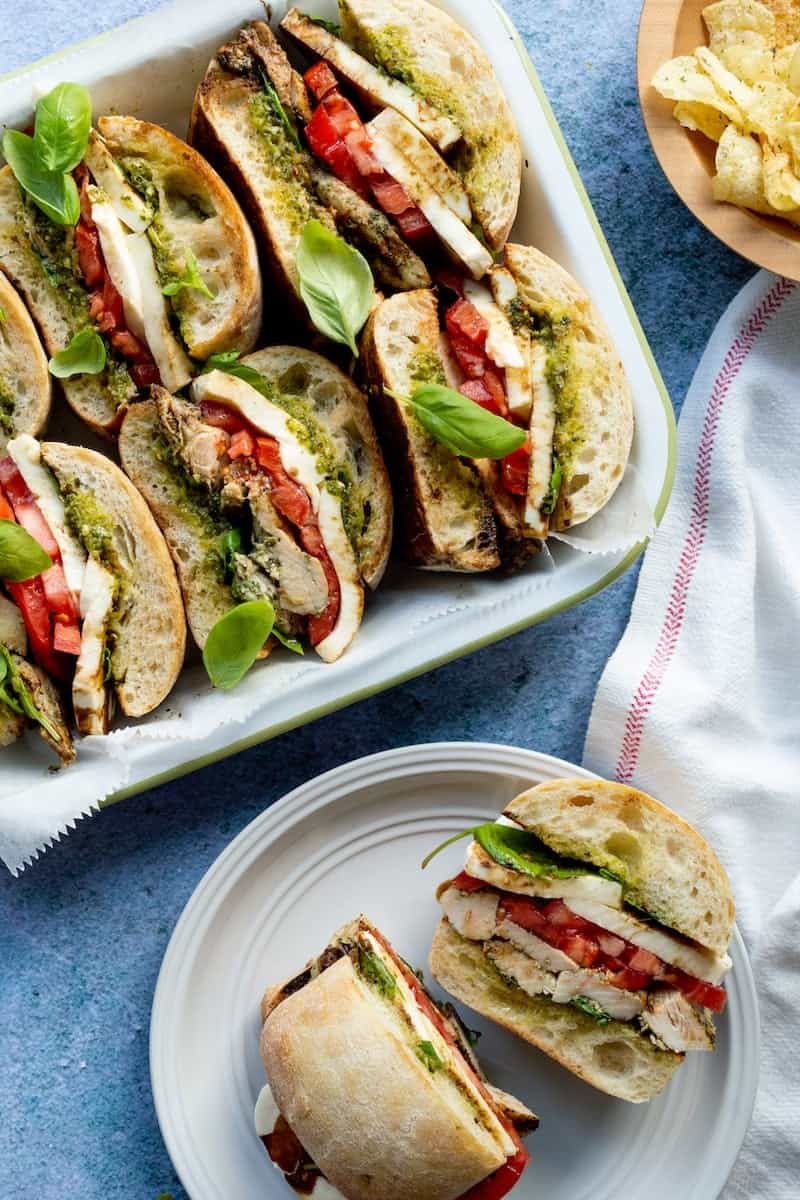 Trader Joe's pesto chicken sandwiches with grilled chicken, fresh mozzarella, tomatoes, basil, and pesto layered between toasted ciabatta bread.